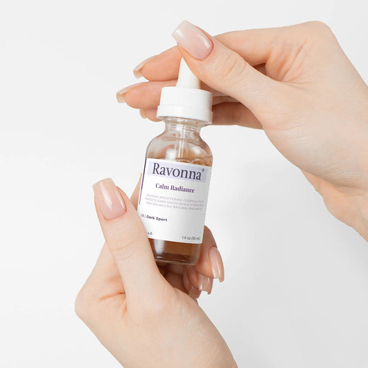 Hands holding Calm Radiance Serum bottle – Ravonna