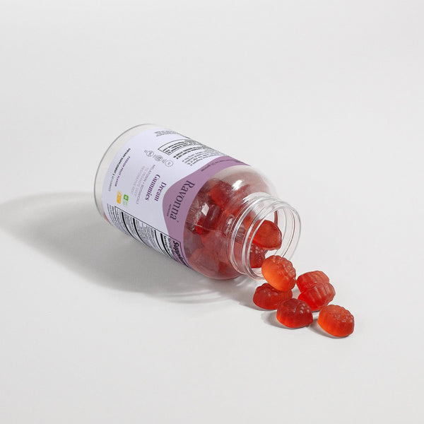 Dream Gummies spilling from open bottle on white background – Ravonna