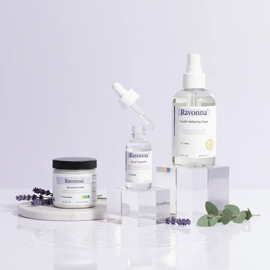 Ravonna skincare products including a jar, bottle with dropper, and other bottles on a light gray background.