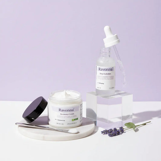 Ravonna skincare products including a jar, dropper bottle, and cream on a light purple background.